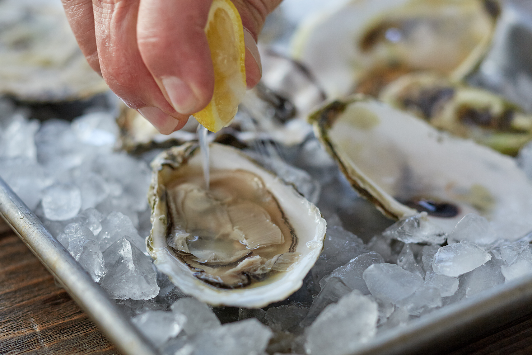 Squeezing lemon on a plate of oysters